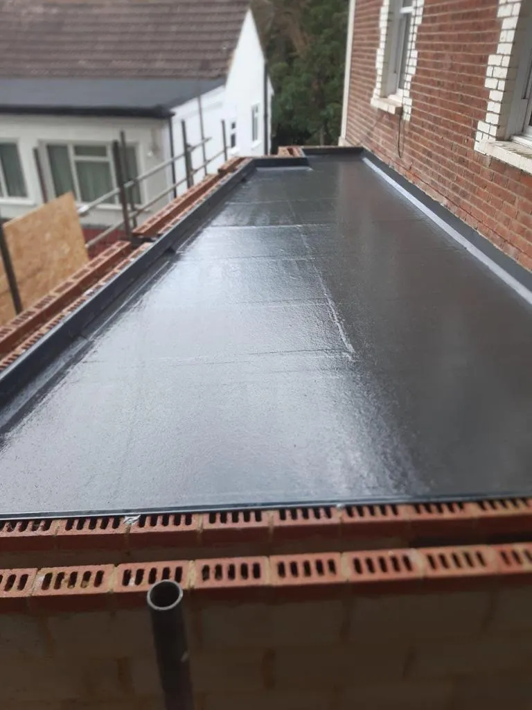 New grey fibreglass flat roof on an extension