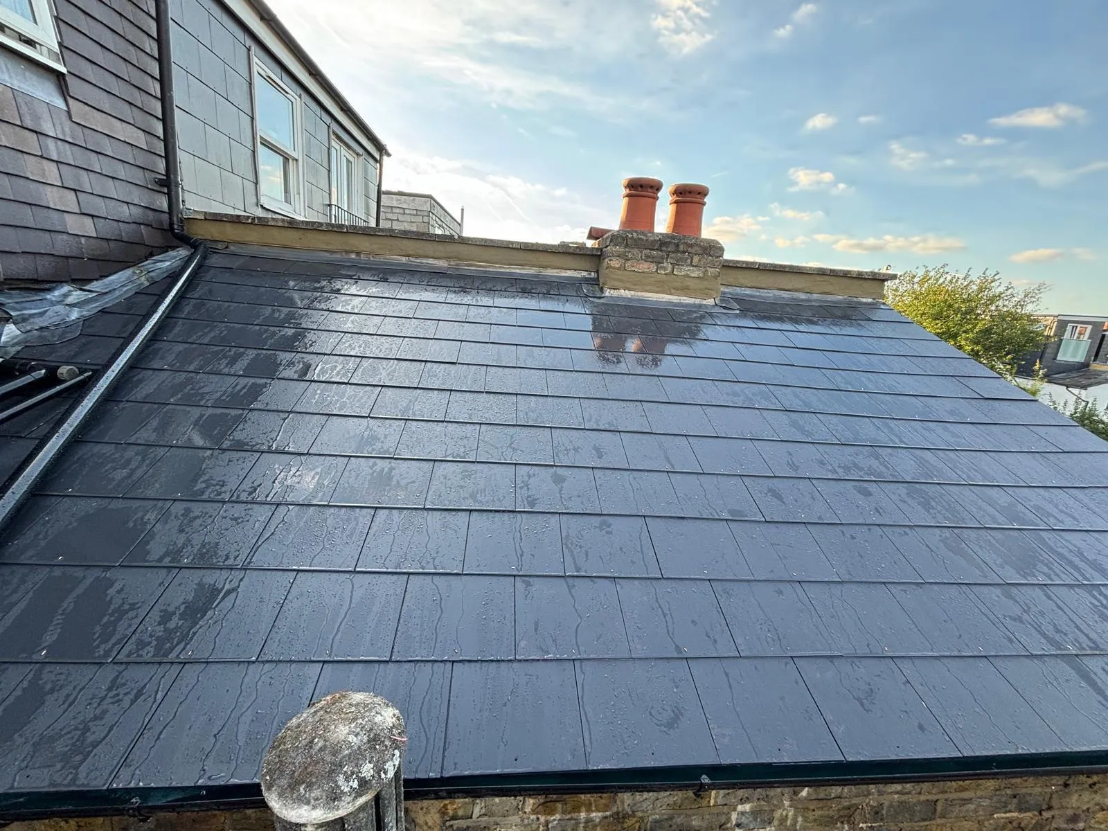 New slate roof with a chimney and pots